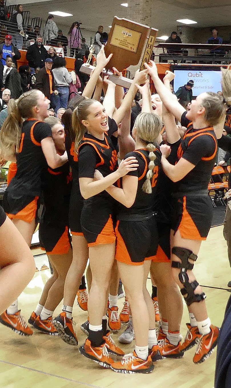 The Warsaw girls basketball team holds up a regional trophy after defeating South Bend Washington 53-43 last Saturday.