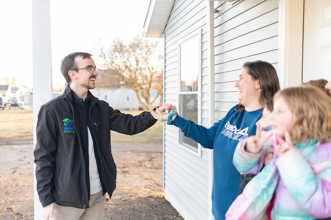 Habitat for Humanity of Kosciusko Executive Director Ben Logan (L) hands over the keys to the home to the Boyd Family recently in Mentone. Photo provided.