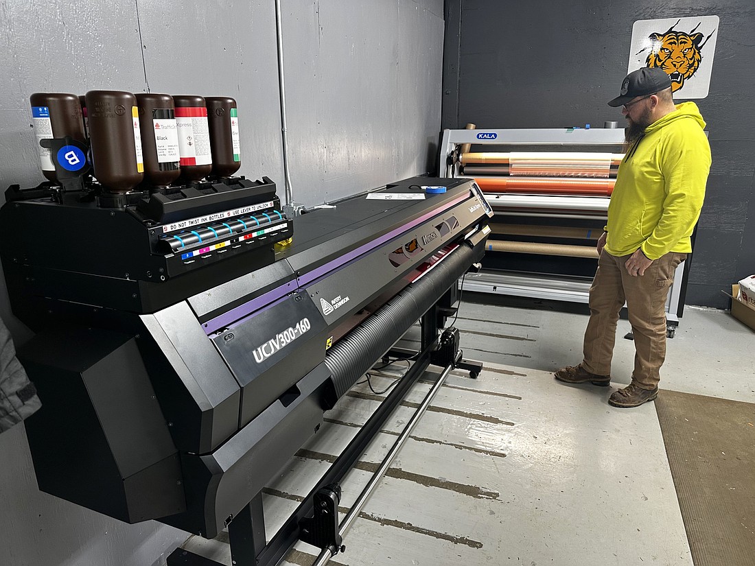 Eric Hoffhien, Warsaw Public Works sign technician and pavement markings technician, uses the Mimaki printer for the Traffic Jet Express Print System from Avery Dennison to make a sign Wednesday. To his right is the laminator for the signs. Photo by David Slone, Times-Union