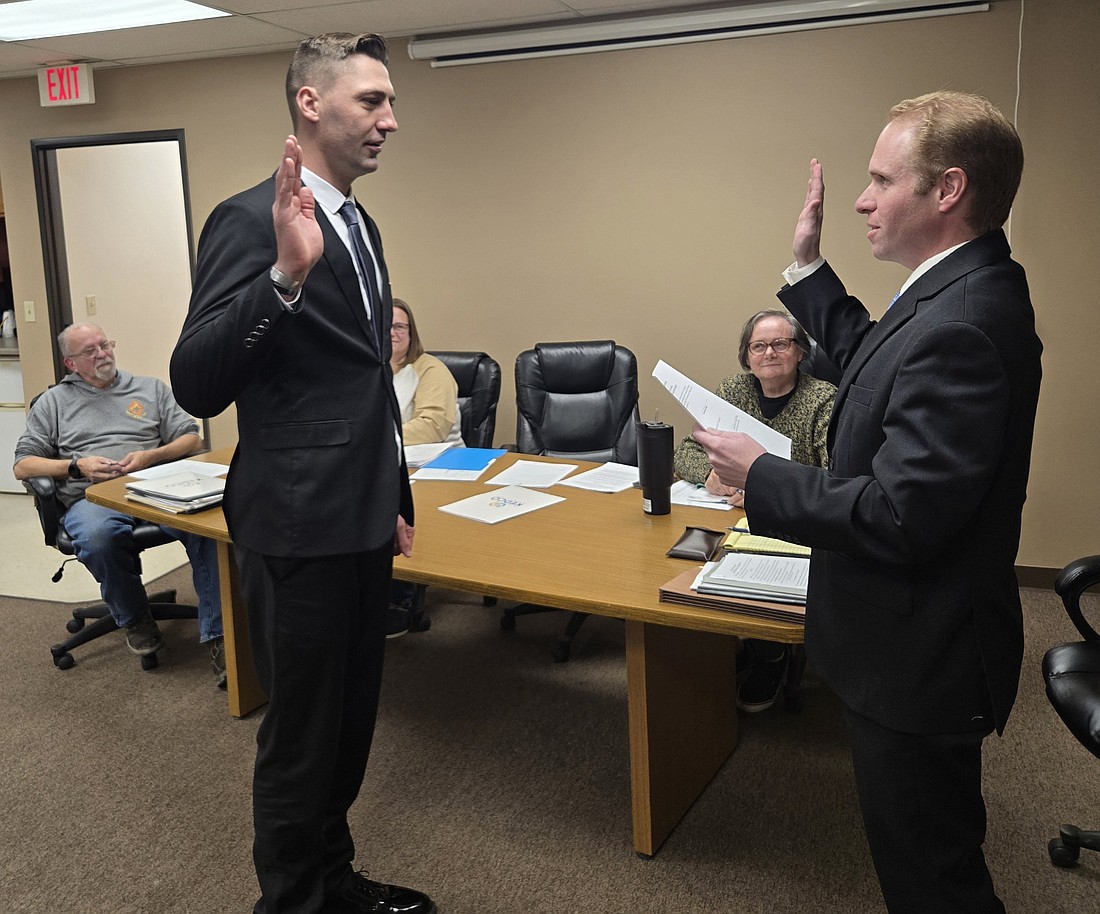 Mentone town attorney Austin Rovenstine (R) swears in Jeremiah Kinsey as deputy marshal Wednesday. Photo by Jackie Gorski, Times-Union