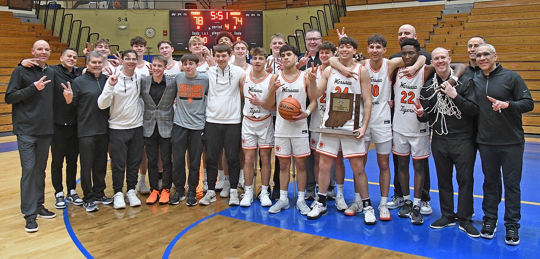 The Warsaw boys basketball team celebrates after beating Northridge in overtime for their second sectional championship in as many years.