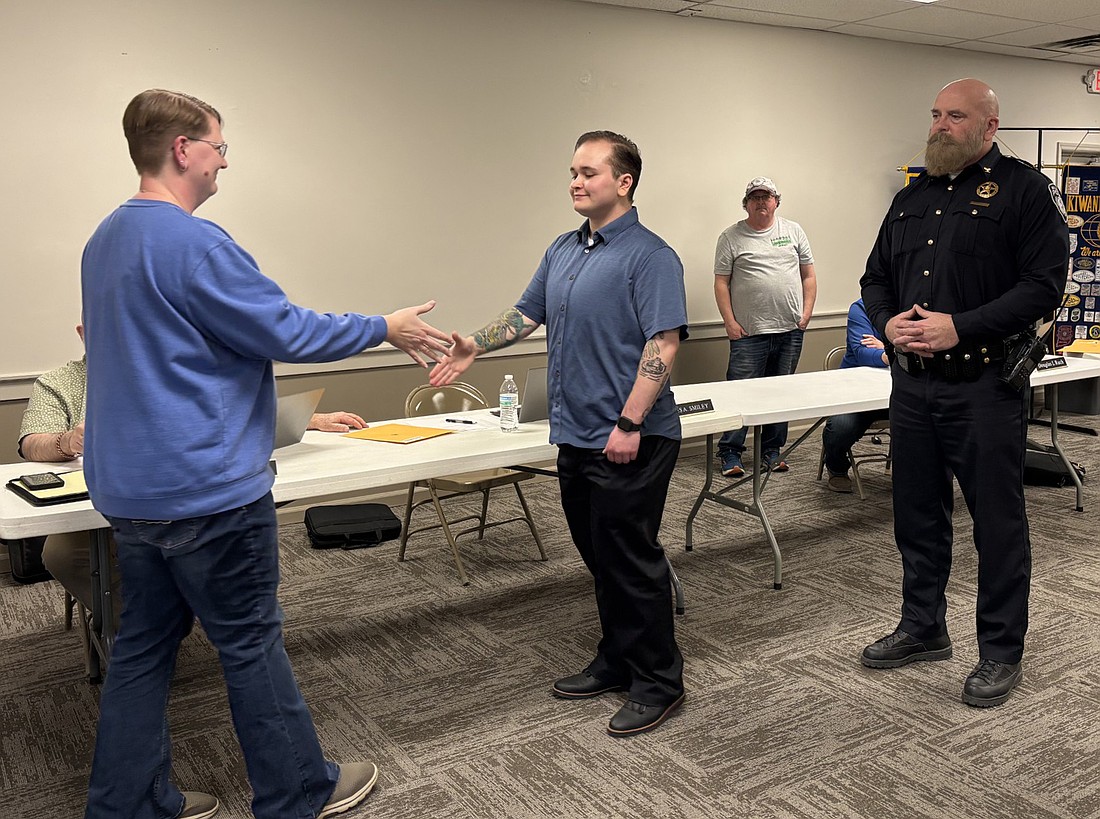 Milford Clerk-Treasurer Tricia Gall (L) congratulates newly sworn in Deputy Marshal Calvin Fancil (C) while Marshal Thomas Waikel (R) watches. Photo by Denise Fedorow