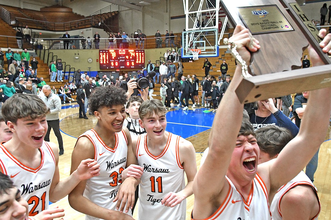 Warsaw senior Reed Nelson screams enjoyment while holding up the sectional trophy from last Saturday's win over Northridge...Nieter