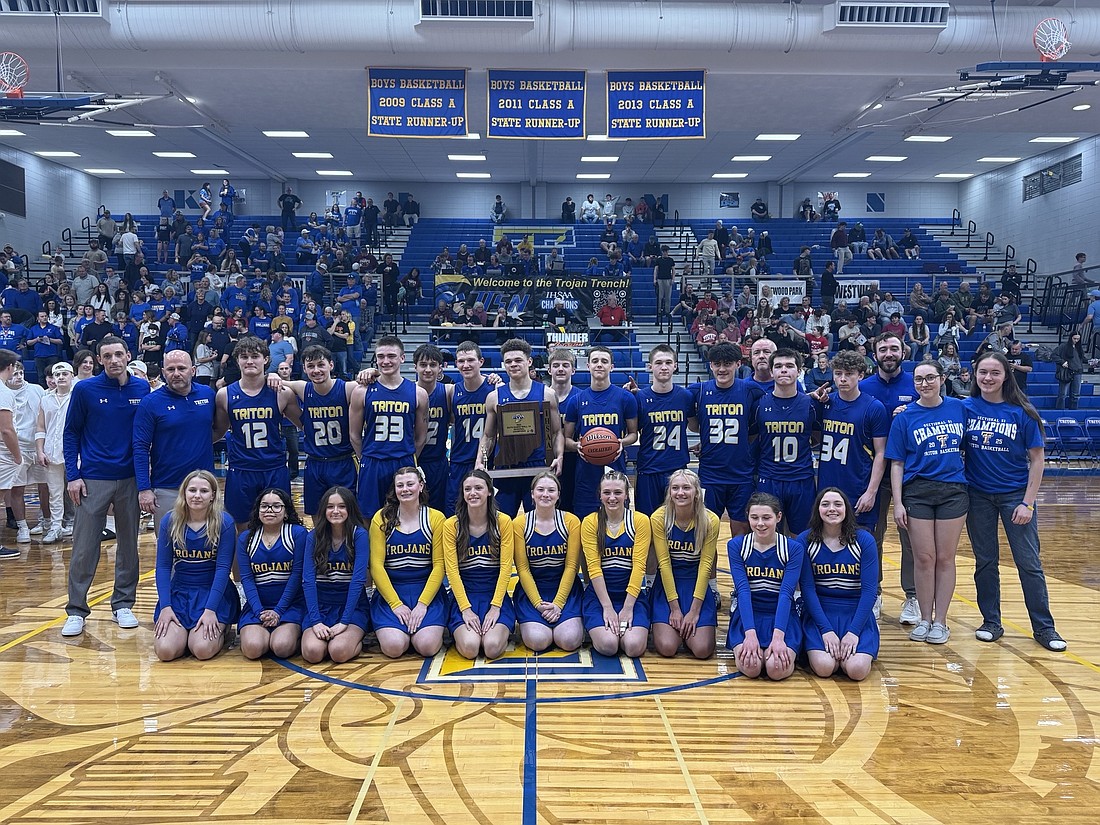 The Triton boys basketball team celebrates after defeating Lakewood Park Christian 63-40 to win a regional championship at home on Saturday.