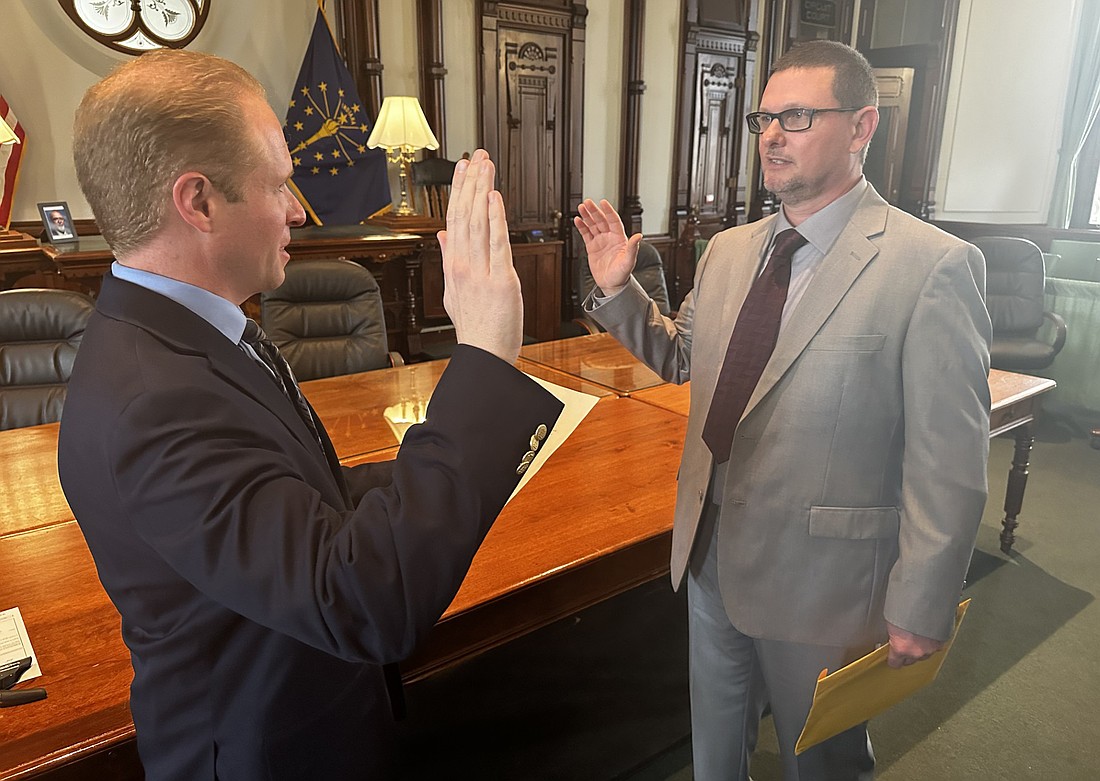 Kosciusko County Republican Party Central Committee Secretary C. Austin Rovenstine (L) gives the oath of office to Joe Irwin (R) after Irwin was selected by a caucus to replace the late Mike Long as the Kosciusko County Council District 2 member. Photo by David Slone, Times-Union