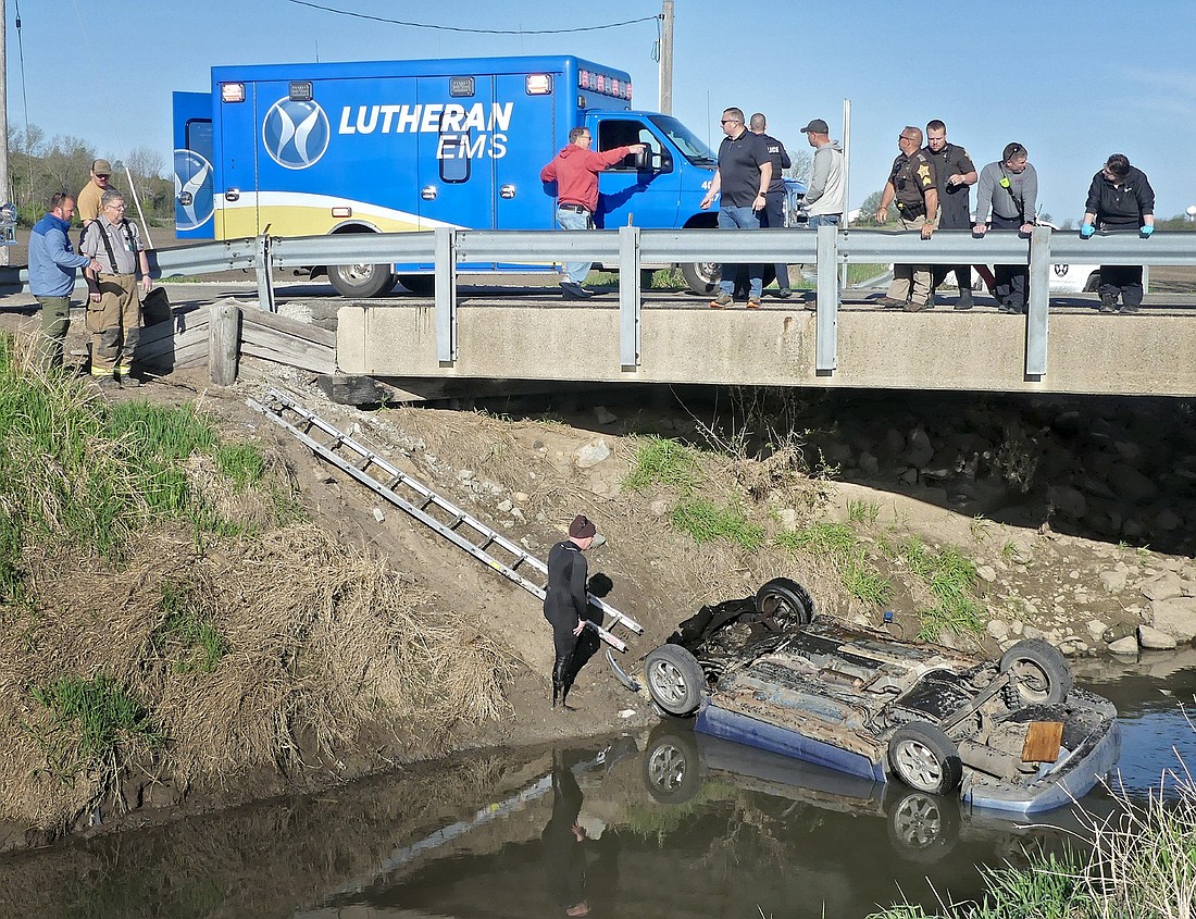 Officials investigate the fatal scene Wednesday morning after a vehicle was discovered upside-down in a ditch along CR 300W, north of CR 1350N. Photo by Gary Nieter, Times-Union.