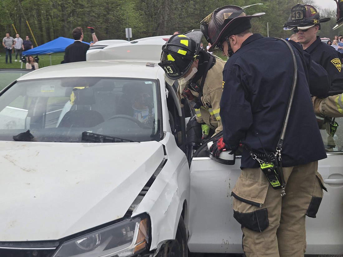 Warsaw-Wayne Fire Territory firefighters try to extricate a Warsaw Community High School student from a car during a mock accident Friday. Photo by Jackie Gorski, Times-Union