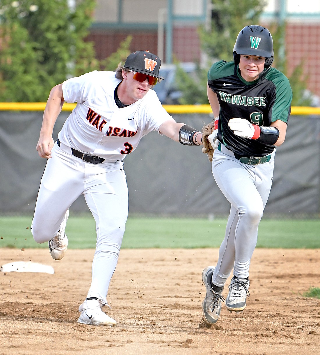 Warsaw's Kellan Bailey puts the tag on Wawasee's Finley Miller during a run down in the fourth inning...Nieter