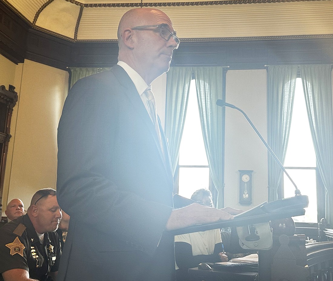 Alan Alderfer (standing), a six-year member of the Merit Board and a local financial adviser, updates the Kosciusko County Council Thursday night on the current state of the Kosciusko County Sheriff’s Office pension plan, with Sheriff Jim Smith listening (sitting). Photo by David Slone, Times-Union