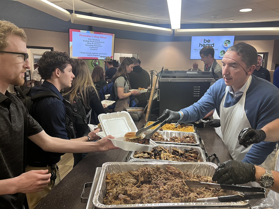 More than 3,000 Zimmer Biomet team members and retirees came together to mark the company’s 98th anniversary of its founding this past week. Pictured is President and CEO Ivan Tornos (R) serving meals to employees. Photo Provided